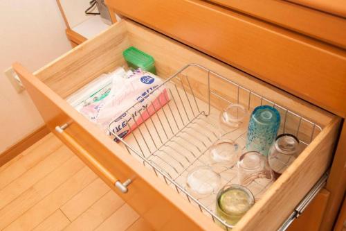 a drawer in a cabinet filled with items at 那覇市内を満喫したいあなたへ！大人数宿泊可！国際通りまで徒歩4分！無料駐車場1台＆Wifi完備！ in Makishimachi