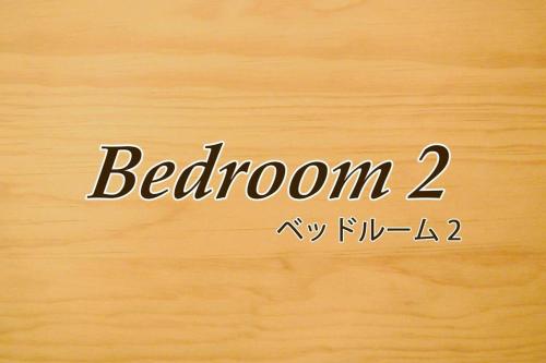 a sign with the word bedroom written on a wooden wall at 那覇市内を満喫したいあなたへ！大人数宿泊可！国際通りまで徒歩4分！無料駐車場1台＆Wifi完備！ in Makishimachi