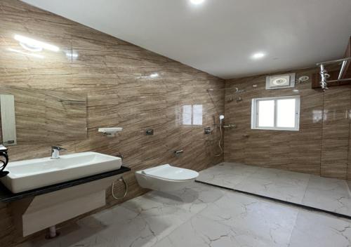 een badkamer met een wastafel en een toilet bij D Royal Palm in Jorhat