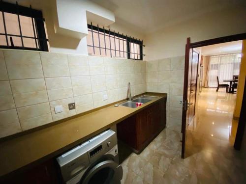 a kitchen with a sink and a washing machine at Marangu (3bedroom) in Lusaka