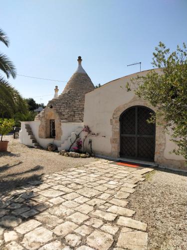 a building with a stone driveway in front of it at Trullo Felice in Ostuni