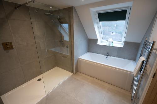 a bathroom with a shower and a tub and a sink at Forest Corner Luxury Home with Hot Tub in North Ballachulish