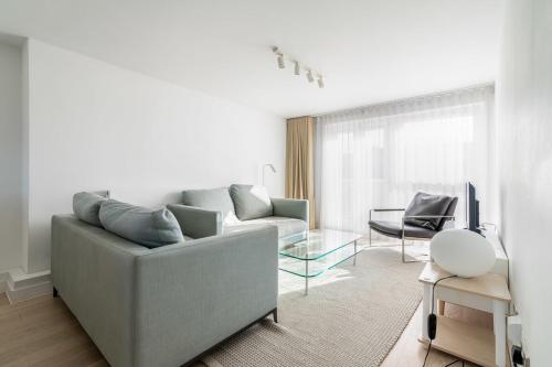 ein Wohnzimmer mit einem Sofa und einem Tisch in der Unterkunft Belgravia Apartment 45 in London