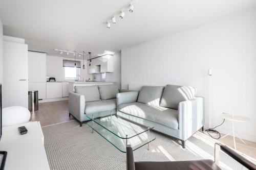 sala de estar con sofá y mesa de cristal en Belgravia Apartment 45, en Londres