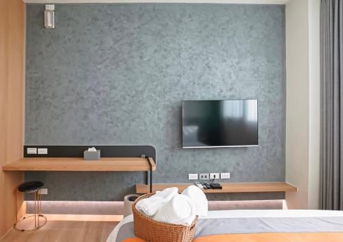 a bedroom with a bed and a tv on a wall at Chun Yuan Zi in Hu-an-liao