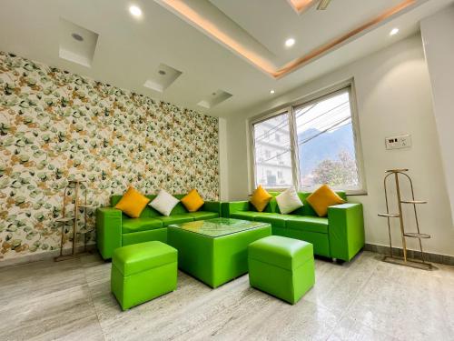 a living room with green couches and orange pillows at Wanna Stay Rishikesh in Rishīkesh