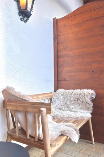 a wooden chair with a furry blanket on it at Ferienwohnung "Bergzeit" in Bad Wiessee