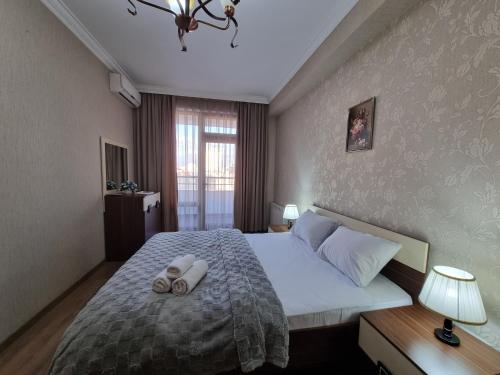 1 dormitorio con 1 cama con 2 toallas en Fontain apartment, en Baku