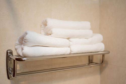 a stack of towels on a towel rack in a bathroom at Monoreach Angkor Hotel in Siem Reap