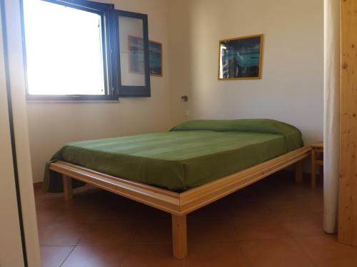 a bed in a room with a window at Il Giardino Ipogeo in Favignana