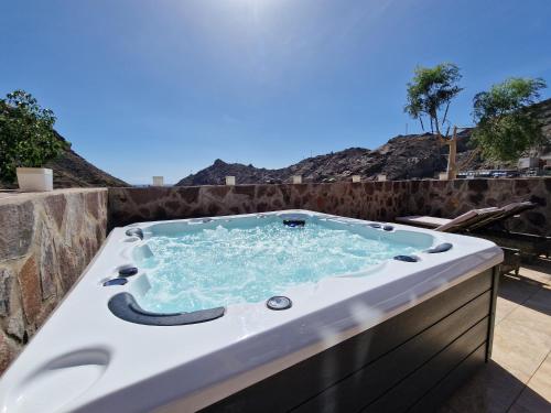 a jacuzzi tub sitting on a patio at Amazing cozy Villa Hugo Tauro with Jacuzzi, Pool, Wi-Fi in Mogán