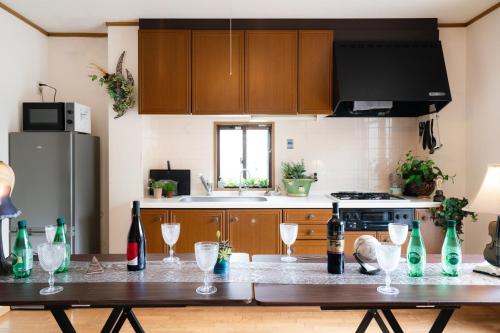 a kitchen with a table with wine bottles and glasses at 最大9名まで宿泊可能三宮駅至近1フロア貸切コンドミニアム in Kobe