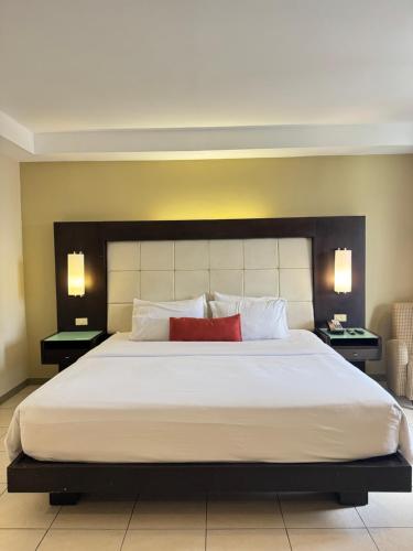 a bedroom with a large white bed with two lamps at Circle Inn - Iloilo City Center in Iloilo City