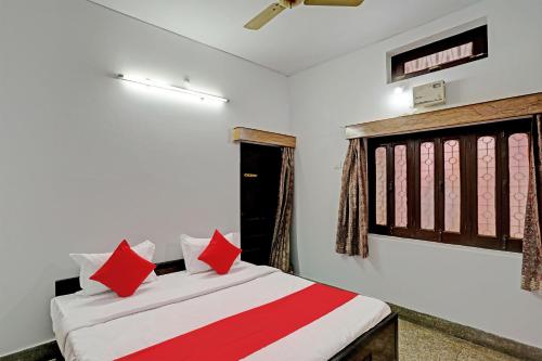 a bedroom with a bed with red pillows at Super OYO Flagship Shivansh Paying Guest House in Varanasi