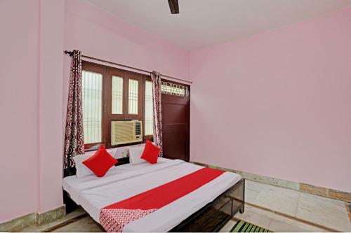 1 dormitorio con 1 cama con almohadas rojas en Super OYO Flagship Shivansh Paying Guest House en Varanasi
