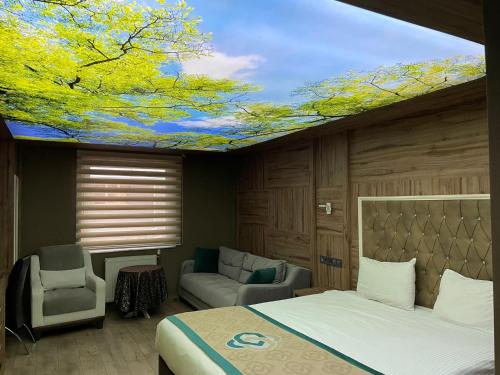a bedroom with a bed and a ceiling with a tree mural at Demosan Hotel in Karaman