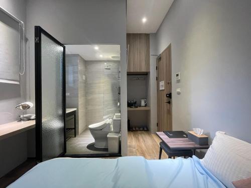 een slaapkamer met een badkamer met een bed en een toilet bij Rooster B&B in Kaohsiung