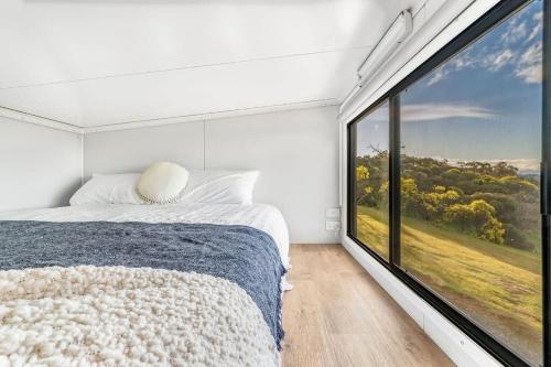 a bedroom with a bed and a large window at Montara Views 3 in Ararat
