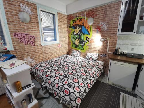 a bedroom with a bed and a brick wall at Street Art Suite in Zagreb
