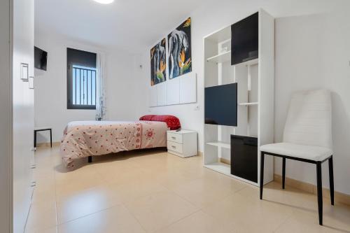 a bedroom with a bed and a chair and a desk at Viudelta in Sant Jaume d'Enveja