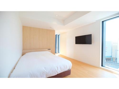 a bedroom with a white bed and a window at HOTEL ASGARD - Vacation STAY 80328v in Hirakata