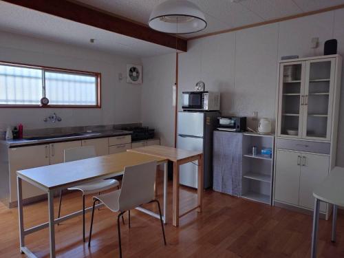 cocina con mesa y sillas en una habitación en 39guest house, en Ibusuki
