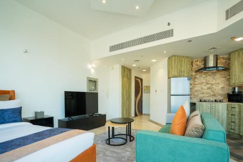 a bedroom with a bed and a couch and a kitchen at CitiHome - Prime Stylish Studio in Sports City in Dubai