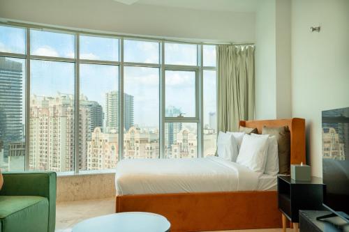 a bedroom with a bed and a large window at CitiHome - Prime Stylish Studio in Sports City in Dubai