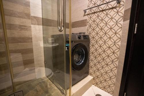 a washer and dryer in a corner of a bathroom at CitiHome - Prime Stylish Studio in Sports City in Dubai