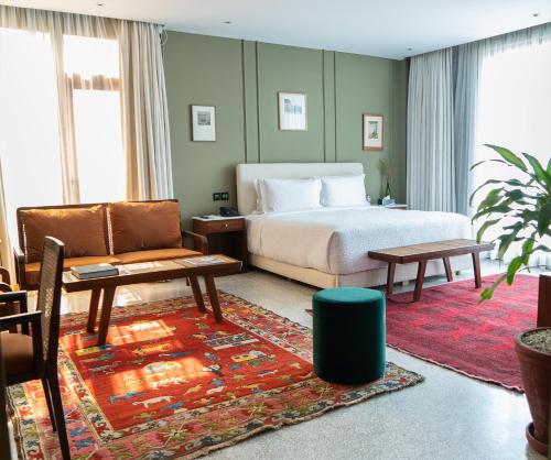 una camera da letto con un letto, un divano e una sedia di The Fred Hotel a Lahore