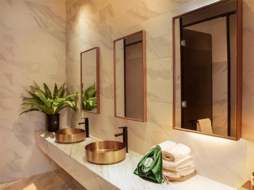 uma casa de banho com 2 lavatórios com espelhos e toalhas em Luo Hotel em Daegu