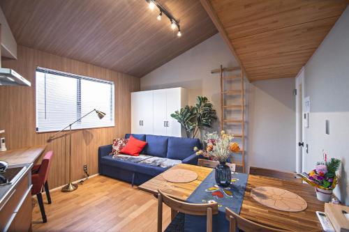 a living room with a blue couch and a table at - 旅time 沐の花 - Kinohana 新築戸建 粉浜駅 in Osaka