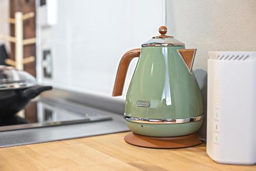 a green tea kettle sitting on top of a counter at - 旅time 沐の花 - Kinohana 新築戸建 粉浜駅 in Osaka