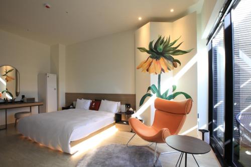 um quarto com uma cama, uma cadeira e uma mesa em Luo Hotel em Daegu