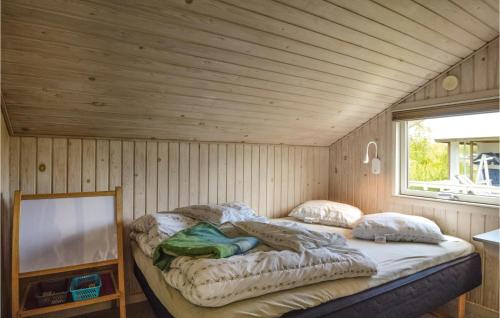 HejlsにあるCozy Home In Hejls With Kitchenの木製の壁のドミトリールームのベッド1台分です。