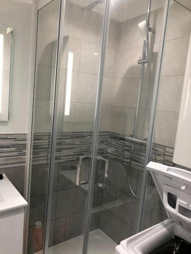 une douche avec une porte vitrée dans une salle de bain dans l'établissement Petite endroit splendide., à Six-Fours-les-Plages