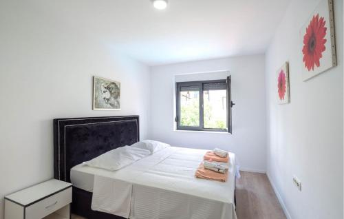ein weißes Schlafzimmer mit einem Bett und einem Fenster in der Unterkunft Awesome Apartment In Kastel Kambelovac With Jacuzzi in Kaštela