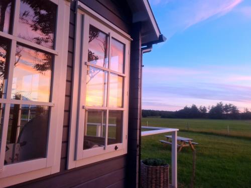 uma janela numa casa com vista para um campo em Little, nice cottage for 2 with beautiful view em Lokken