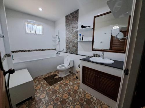 a bathroom with a sink and a toilet and a tub at Jacuzzi Pool Villa in Ban Huai Yai