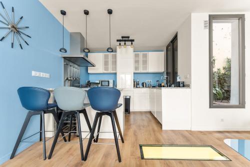 - une cuisine avec des murs bleus et blancs et des chaises bleues dans l'établissement Francs-Bourgeois, à Paris