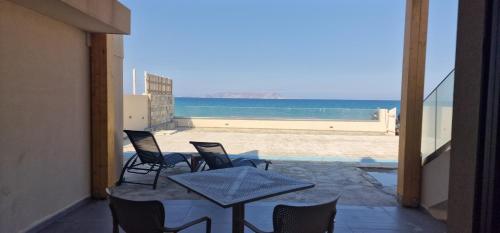 コッキニ・カニオンにあるAlmare Beach Hotelのビーチの景色を望むパティオ(椅子、テーブル付)