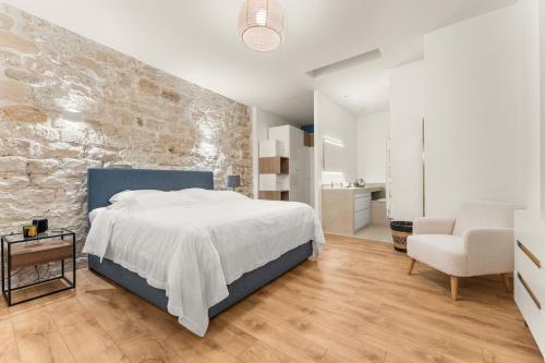 une chambre avec un lit et un mur en pierre dans l'établissement Francs-Bourgeois, à Paris