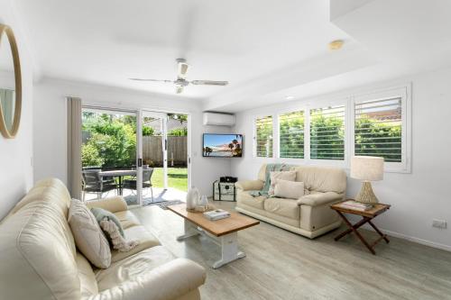 a living room with two couches and a table at Noosa Sunseeker-walk to cafes & river, pet friendly in Noosaville