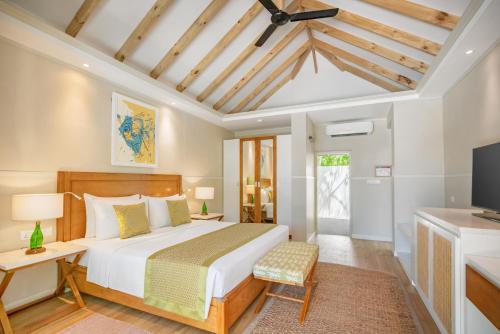 een slaapkamer met een groot bed en een televisie bij Ellaidhoo Maldives by Cinnamon in Hangnaameedhoo