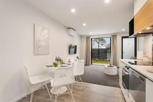 a kitchen and dining room with a table and chairs at Style Location New Sunny 2Bdrms Free Park in Christchurch