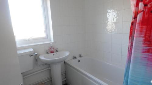 a white bathroom with a sink and a bath tub at Brentwood Townhouse - Huku Kwetu Dunstable -Massive 5 Bedroom House - Suitable & Affordable Group Accommodation - Business Travellers in Houghton Regis