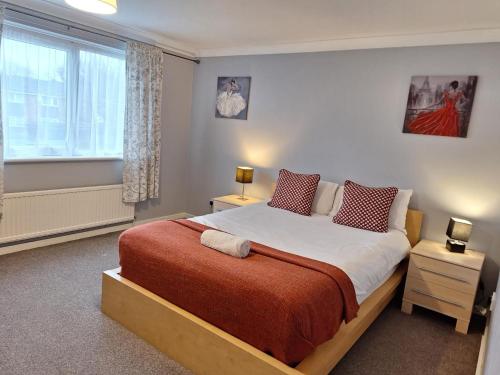 a bedroom with a large bed and a window at Brentwood Townhouse - Huku Kwetu Dunstable -Massive 5 Bedroom House - Suitable & Affordable Group Accommodation - Business Travellers in Houghton Regis