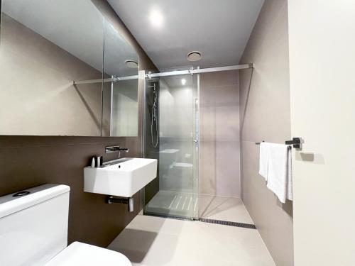 a bathroom with a shower and a toilet and a sink at Collins Serviced Apartments in Melbourne