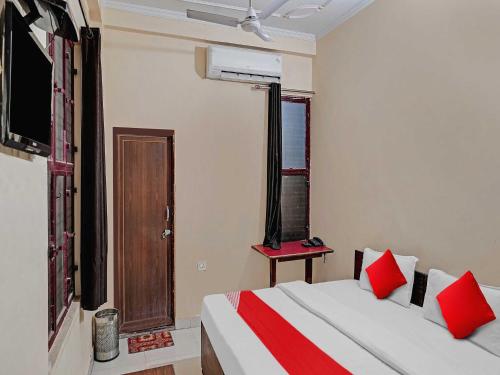1 dormitorio con 2 camas con almohadas rojas y ventana en OYO Flagship Hare Rama Hotel en Chaukhandi