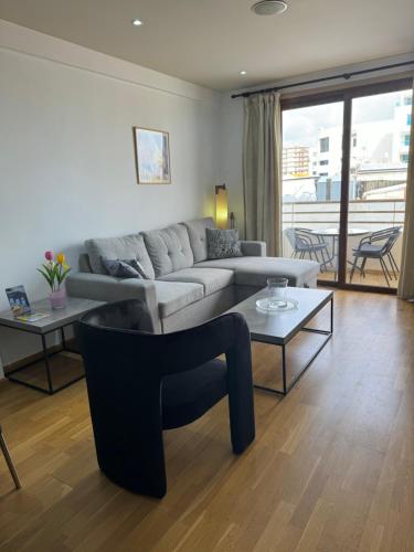 a living room with a couch and a table at Ithaki Phinikoudes Apartment No. 105 in Larnaka